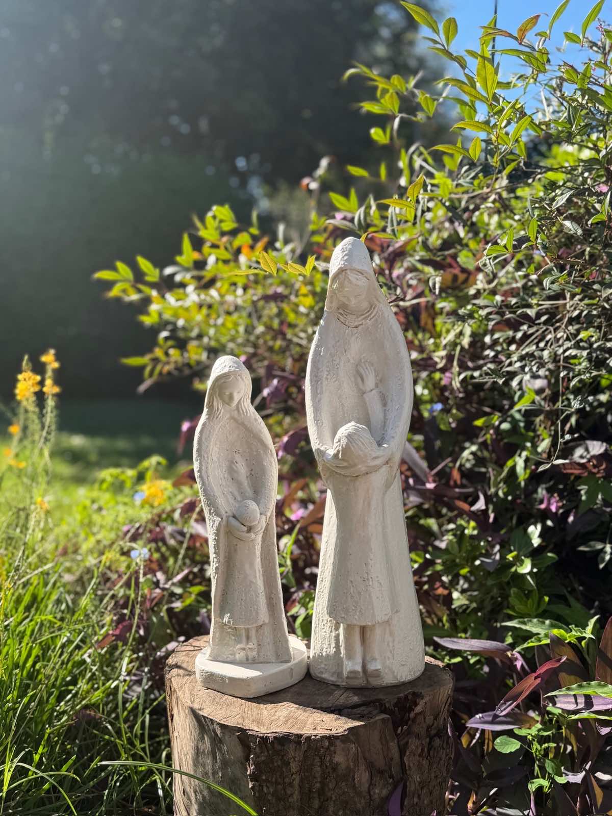 Dos imágenes de resina sobre un tronco en el jardín, a contraluz